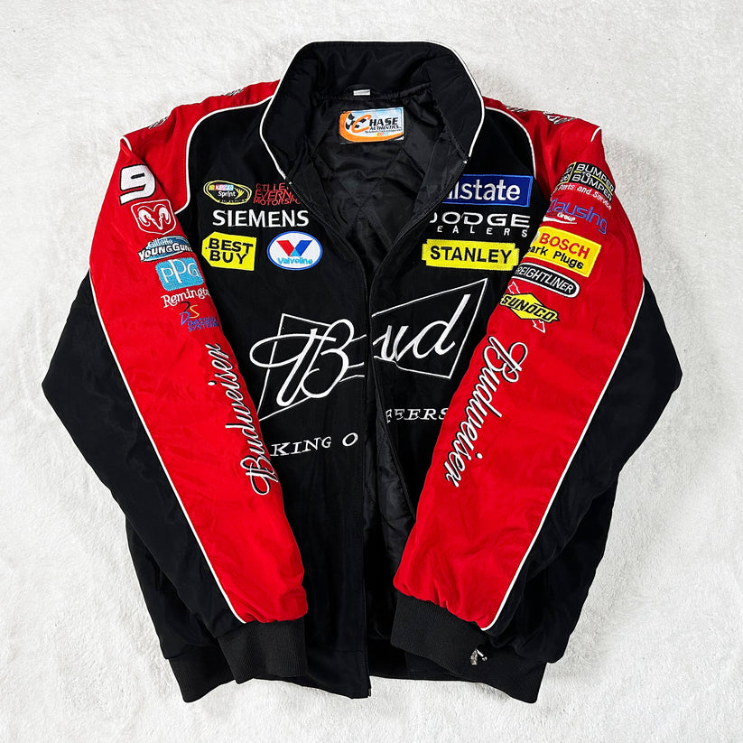 The Budweiser Vintage Racing Jacket - NASCAR Black Edition in black and red features Budweiser branding on the front, with Siemens, Dodge, Best Buy, and Stanley sponsor patches on the sleeves and chest.