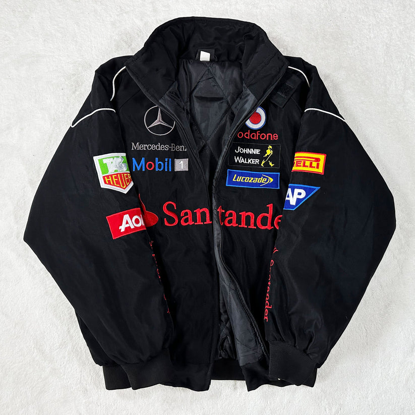 The Mercedes-Benz Santander Vintage Jacket in black, featuring authentic sponsor logos, showcases classic motorsport heritage and stealth racing style, displayed flat on a white surface.