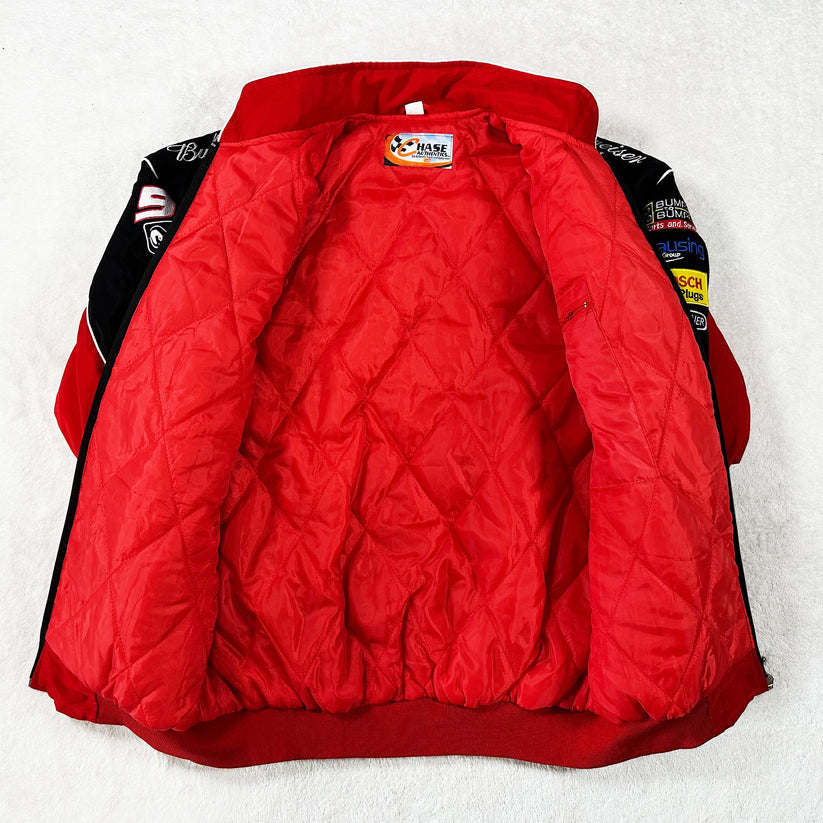 The Budweiser Racing Vintage Jacket - NASCAR Red Edition is displayed open on a white surface, showcasing its quilted red lining and multiple patches and logos on the sleeves and collar for an authentic vintage motorsport vibe.