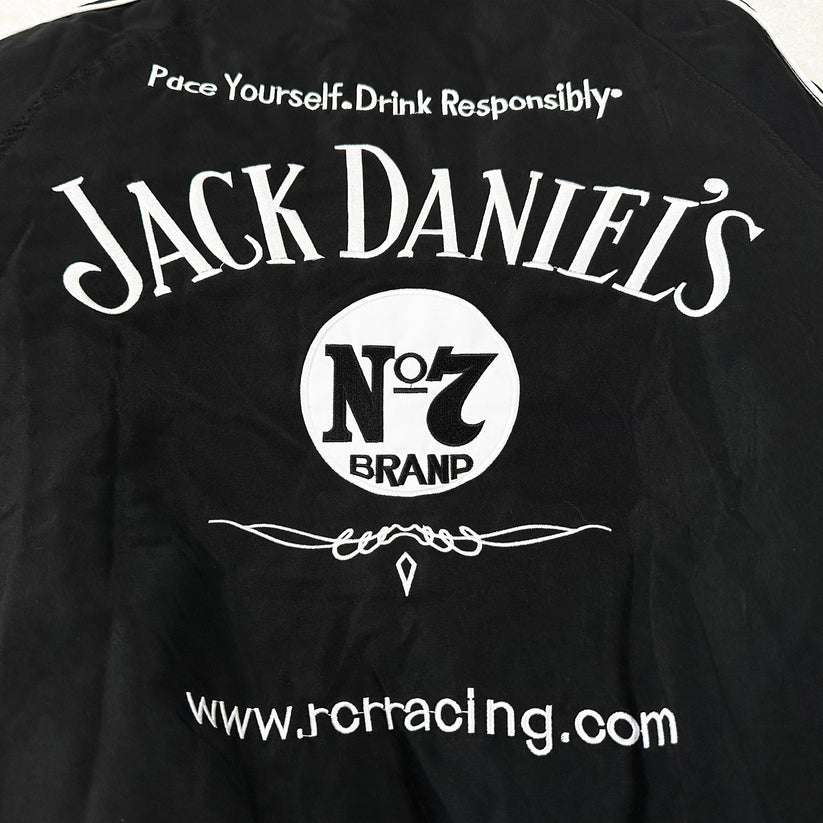 The Jack Daniel’s Racing Vintage Jacket features black fabric with white Pace Yourself. Drink Responsibly. text, JACK DANIELS No. 7 BRAND, a decorative line, and www.jcracing.com—perfect for racing-inspired streetwear fans.
