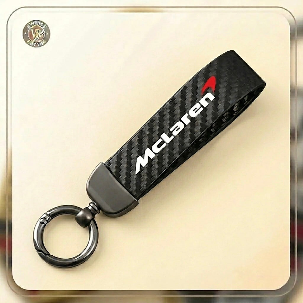 The McLaren Keychain, a carbon fiber supercar accessory, displays the McLaren logo in white and red text on a sleek design and includes a sturdy metal ring for your keys.