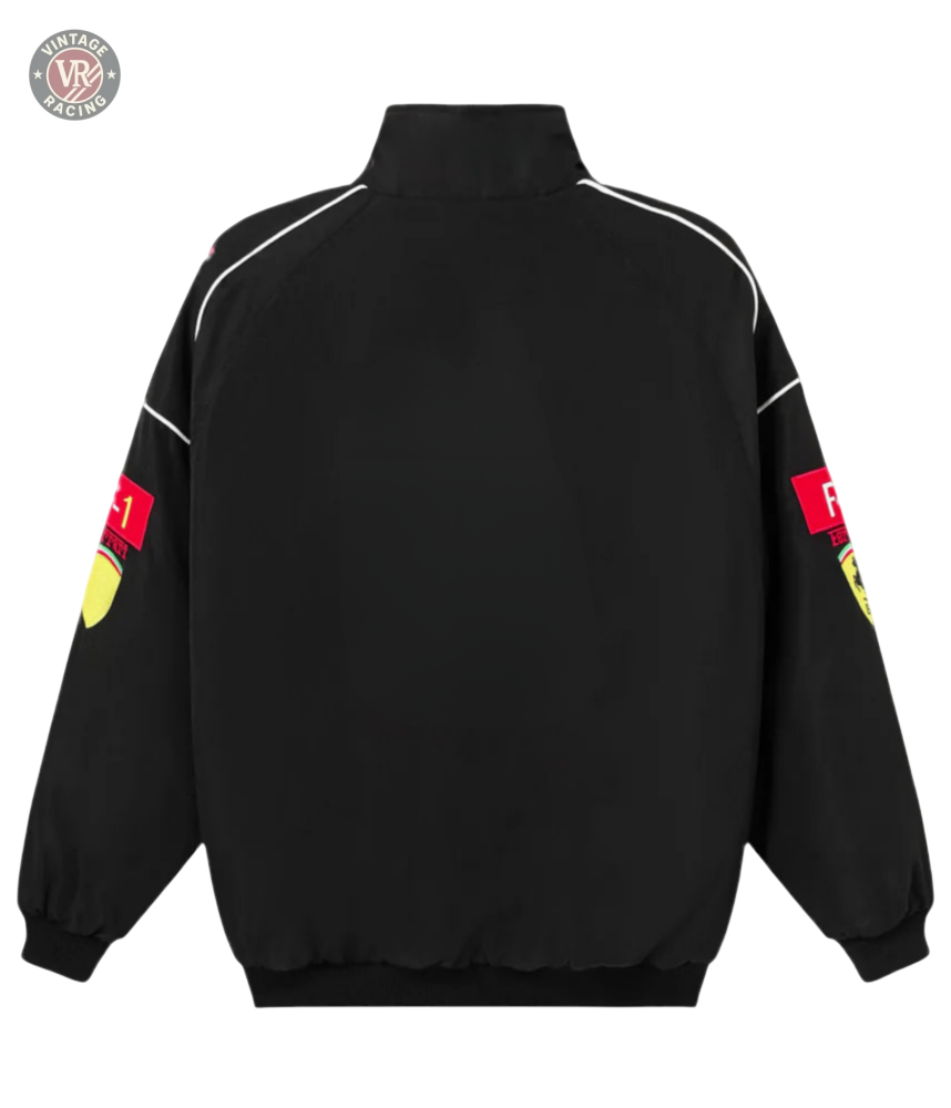 The F1 Vintage Racing Jacket - Black Edition features a retro motorsport look with white piping, elastic cuffs and hem, plus red Scuderia Ferrari F1 logos with yellow crests on the upper sleeves, seen from the back.