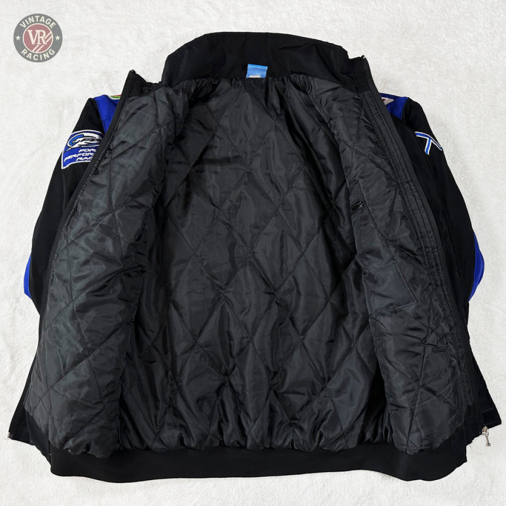 A Ford Vintage Jacket - Performance Edition in black is displayed open, showcasing its quilted lining and sleeves with blue and black panels accented by embroidered patches inspired by classic racing heritage.