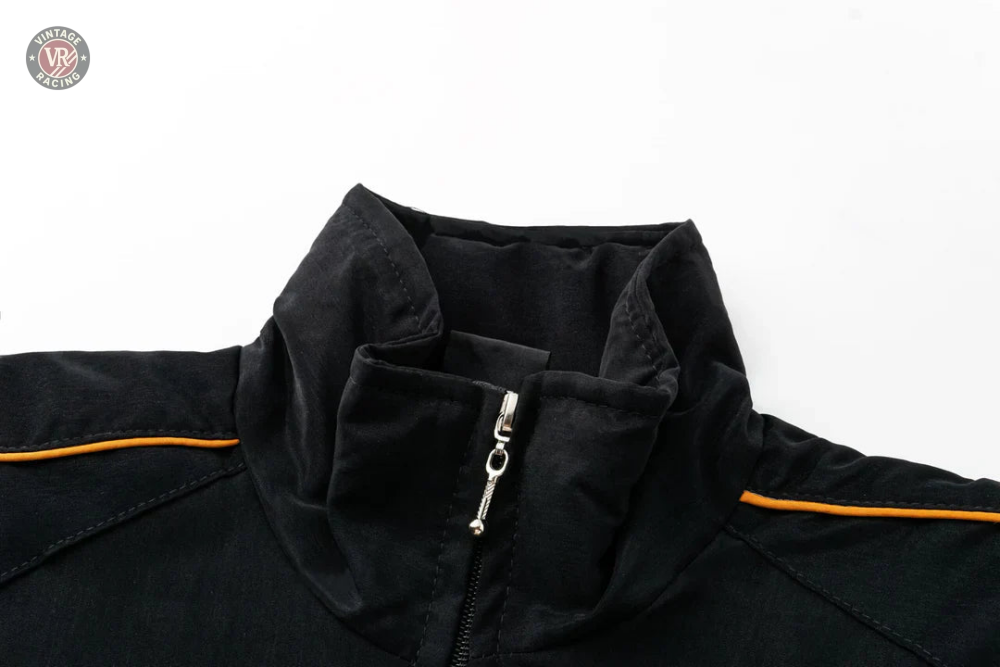 Close-up of the upper part of the Lamborghini Vintage Racing Jacket, featuring a high collar, silver zipper, and orange piping along the shoulder seams—perfect for motorsport enthusiasts, shown on a white background.