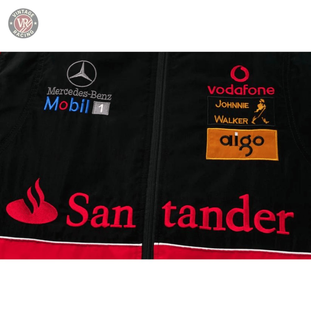 Close-up of the McLaren x Mercedes-Benz Vintage Jacket, a black Grand Prix jacket with Mercedes-Benz, Mobil 1, Vodafone, Johnnie Walker, aigo, and Santander logos plus red, white, and yellow embroidery—a Formula 1 streetwear classic.