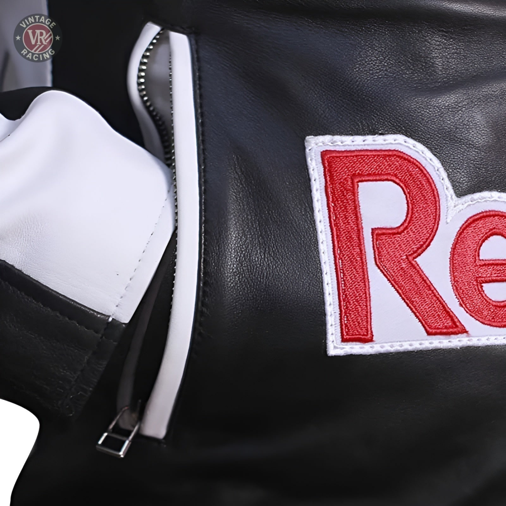 Close-up of the Red Bull Leather Racing Jacket in black and white, featuring a white zipper and a red and white embroidered Re patch, showcasing its racing-inspired design.