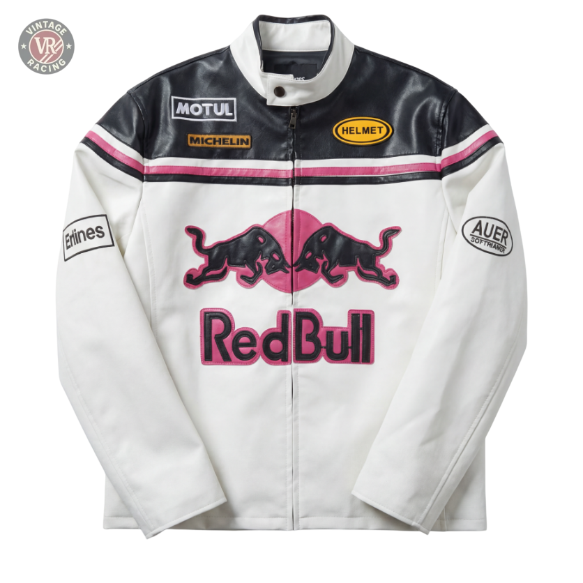 The Red Bull Leather Racing Jacket - White & Pink Edition features a white and black design with pink accents, a large Red Bull logo on the front, black bulls, and patches from Motul, Michelin, Helmet, Etnies, and Auer Sportlabel.