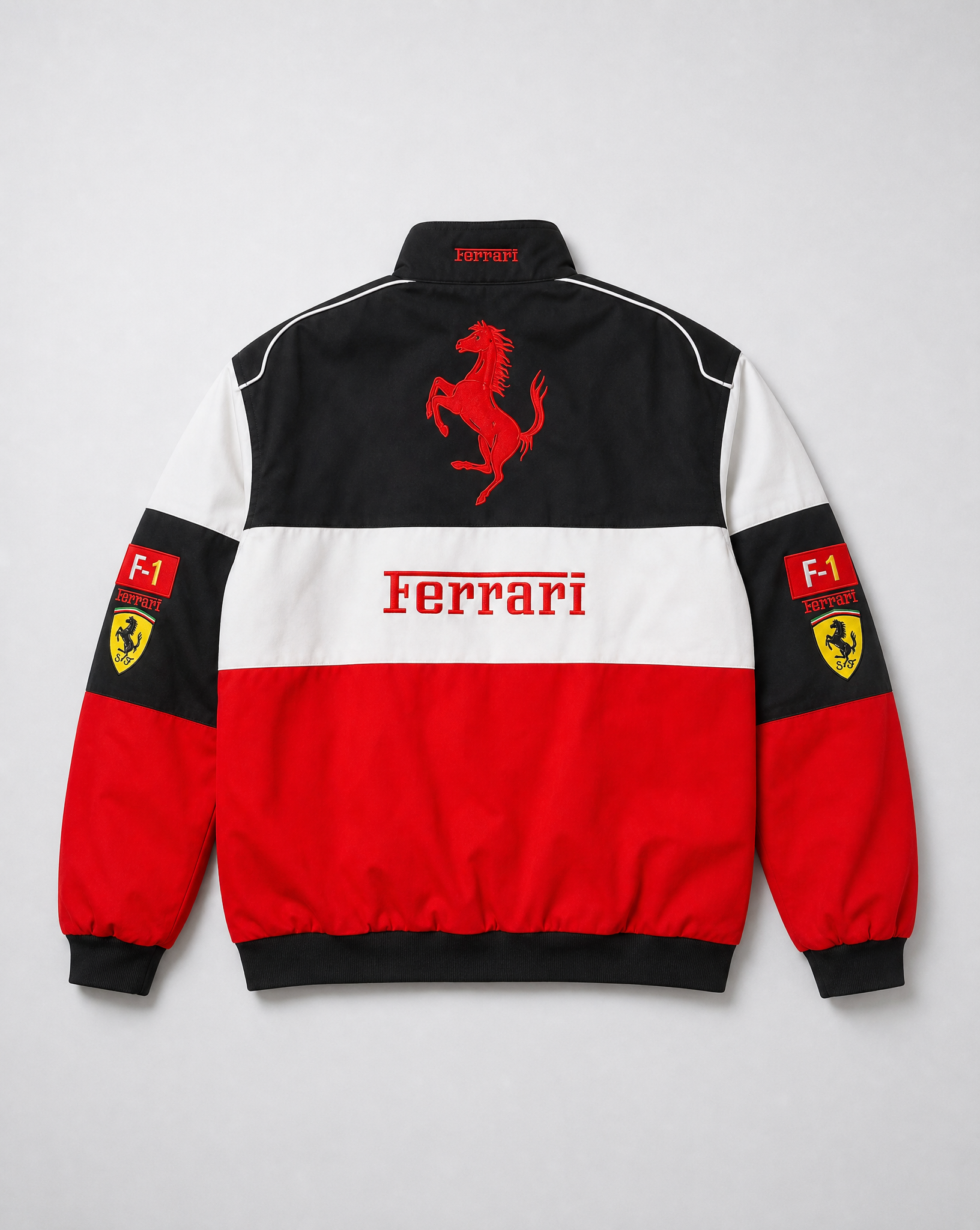 The F1 Ferrari Vintage Racing Jacket - Black, White & Red Edition features retro color panels, a prancing horse logo, “Ferrari” text, and shield patches on the sleeves for an iconic motorsport look.