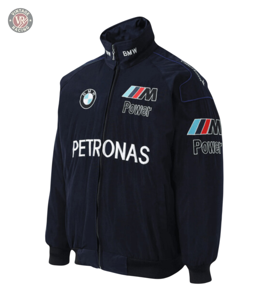 The BMW F1 Vintage Racing Jacket - Classic Edition is a navy blue jacket featuring embroidered BMW, M Power, and Petronas logos, with zip closure, stand collar, elastic cuffs and hem—a must-have for motorsport fans.
