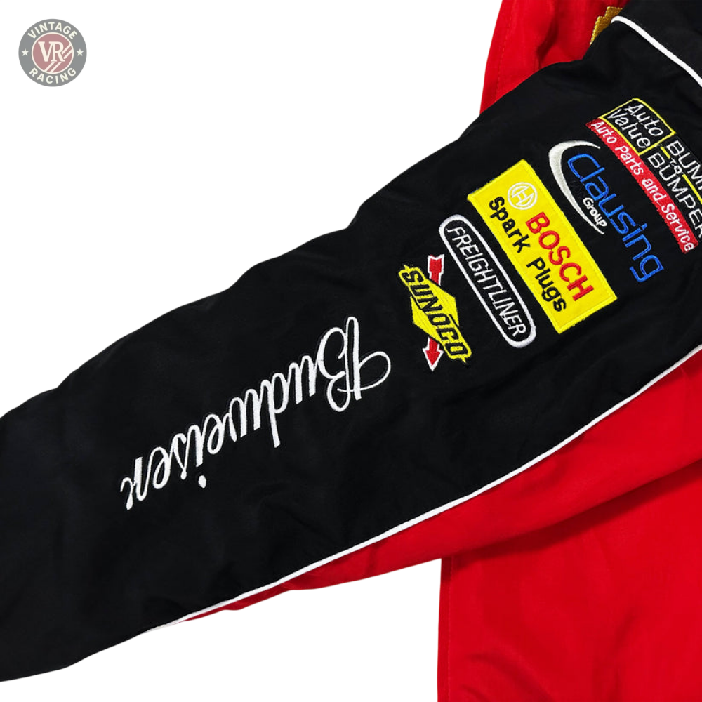 A close-up of the Budweiser Racing Vintage Jacket - NASCAR Red Edition sleeve, showing embroidered Budweiser, Bosch, Snap-on, Freightliner, and Clausing logos on black fabric with white piping and red accents for a classic motorsport look.