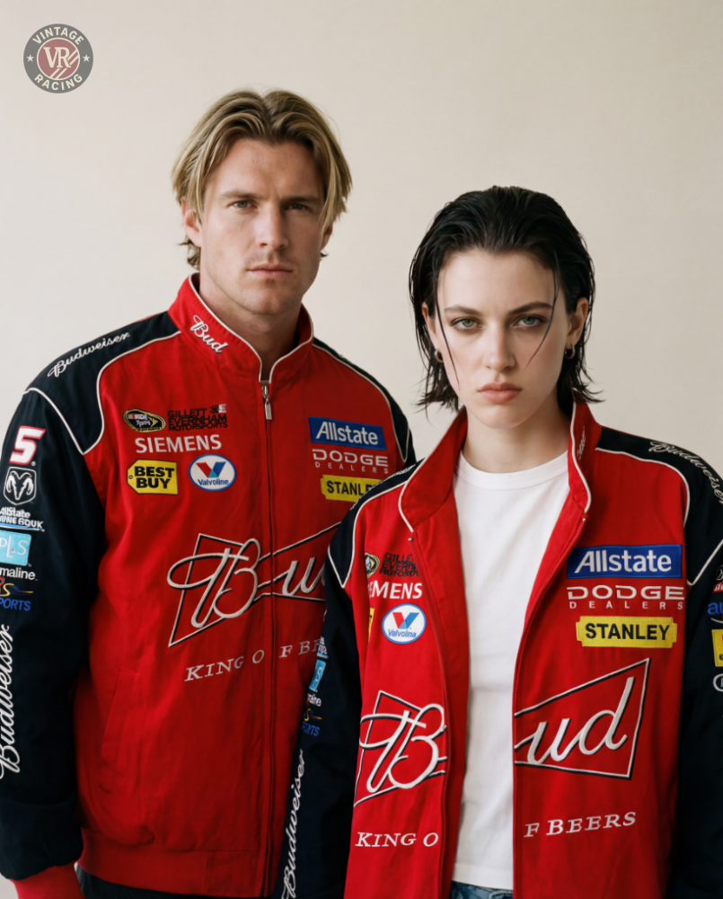 Two people wear Budweiser Racing Vintage Jacket - NASCAR Red Edition with sponsor logos, standing side by side against a plain beige background and looking directly at the camera with serious expressions.