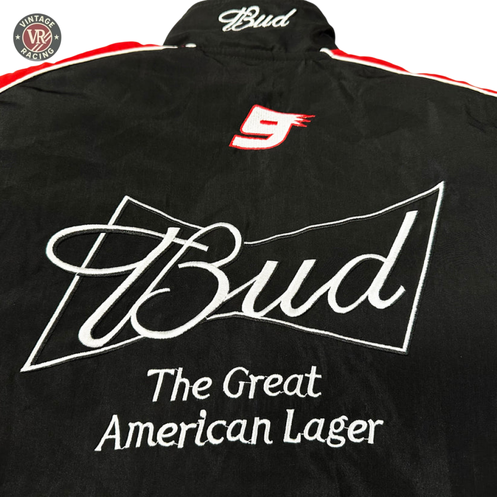 The Budweiser Vintage Racing Jacket - NASCAR Black Edition is a black jacket with red and white accents, featuring embroidered “Bud” in white, a red number 9, and the slogan “The Great American Lager.”.