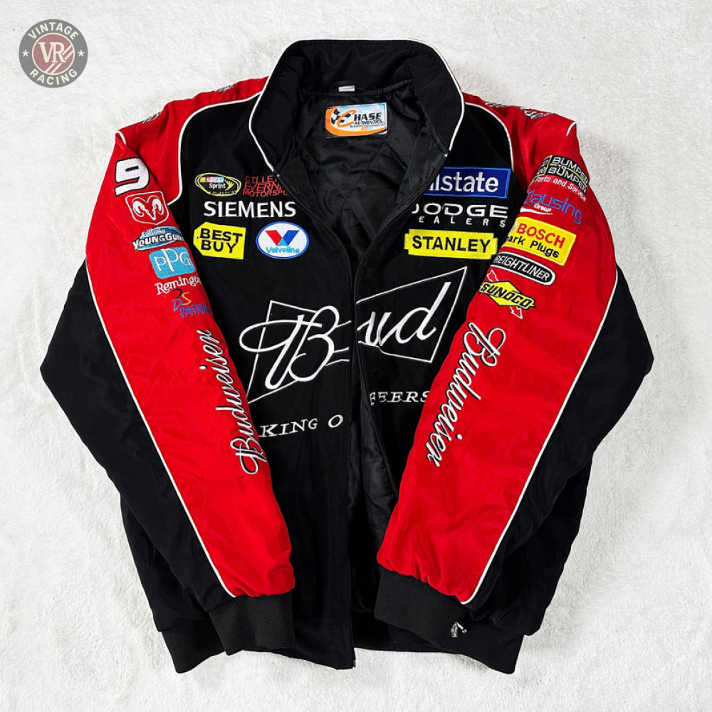 The Budweiser Vintage Racing Jacket - NASCAR Black Edition in black and red features Budweiser branding on the front, with Siemens, Dodge, Best Buy, and Stanley sponsor patches on the sleeves and chest.