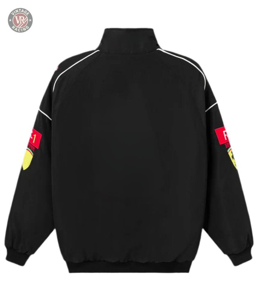 The F1 Vintage Racing Jacket - Black Edition features a retro motorsport look with white piping, elastic cuffs and hem, plus red Scuderia Ferrari F1 logos with yellow crests on the upper sleeves, seen from the back.