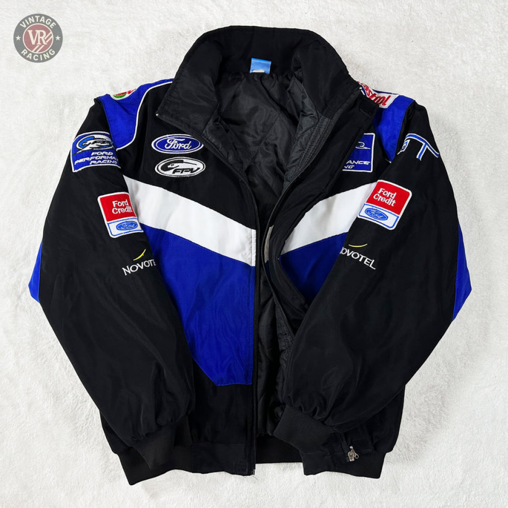 The Ford Vintage Jacket - Performance Edition in black, blue, and white features racing heritage with Ford and Fort Chiswell sponsor logos on the chest, sleeves, and shoulders, displayed on a white surface.