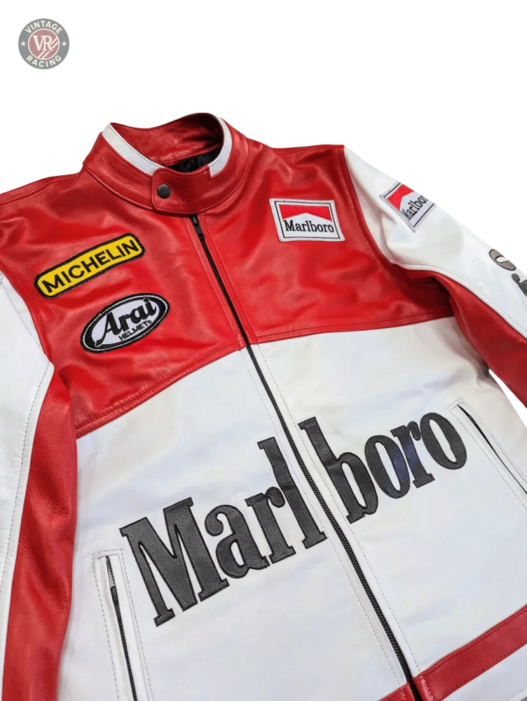 The Marlboro Racing Leather Jacket, shown on a light gray background, features bold red and white Marlboro branding with Michelin and Arai patches on the chest and arms for a classic retro motorsport look.
