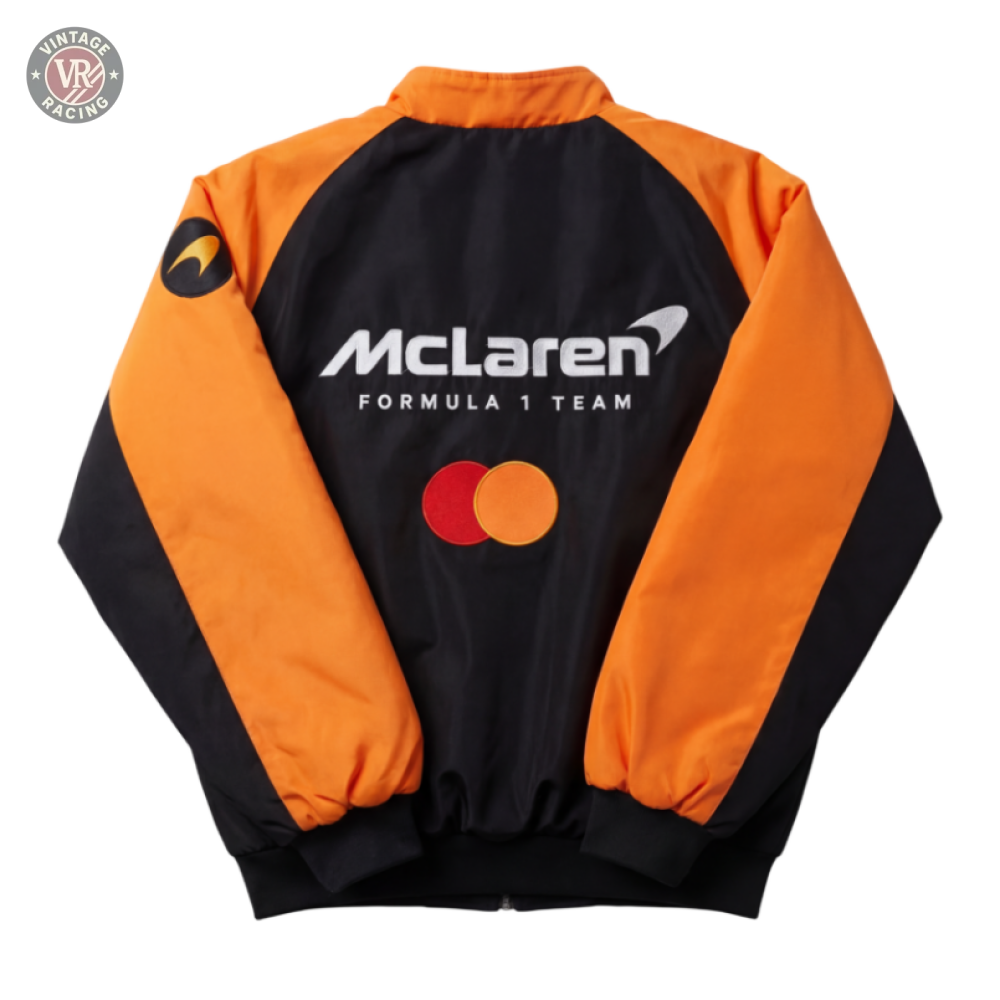 The Mclaren F1 Vintage Racing Jacket, shown on a neutral background, features orange and black colors with the McLaren logo, Mastercard logo, and a circular emblem on the sleeve.