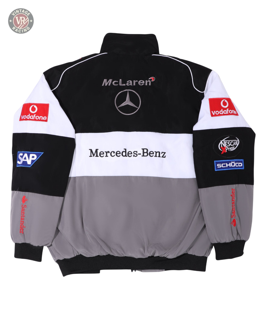 The McLaren F1 x Mercedes-Benz Vintage Jacket sports McLaren and Mercedes-Benz logos on the back, plus Vodafone, SAP, Santander, and Schüco sponsor patches on sleeves and shoulders. Available in classic black, white, and gray.