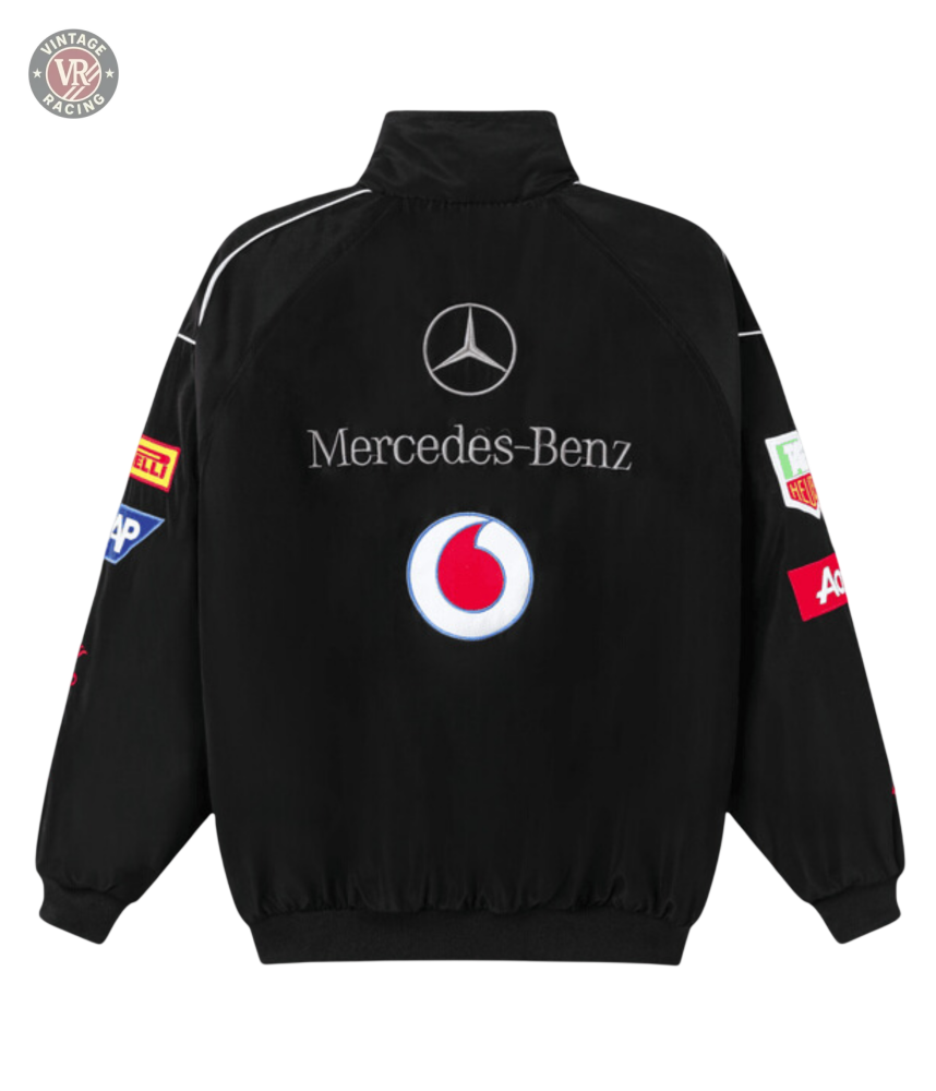 The Mercedes-Benz Santander Vintage Jacket is black with a stealth racing style, featuring Vodafone, Pirelli, Mobil 1, and ACDelco logos on the back and sleeves plus a high collar and ribbed cuffs and hem.