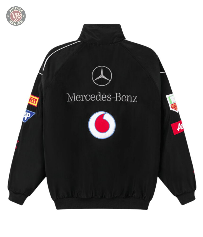 The Mercedes-Benz Santander Vintage Jacket is black with a stealth racing style, featuring Vodafone, Pirelli, Mobil 1, and ACDelco logos on the back and sleeves plus a high collar and ribbed cuffs and hem.