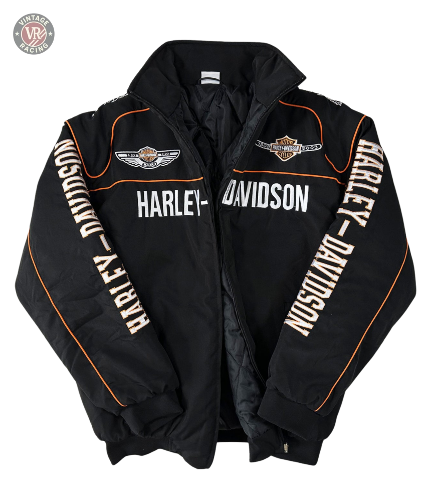 The Vintage Harley Davidson Jacket is black with orange piping, embroidered chest and shoulder logos, and HARLEY-DAVIDSON text on the front and sleeves. The retro motorcycle jacket is displayed flat on a white background.
