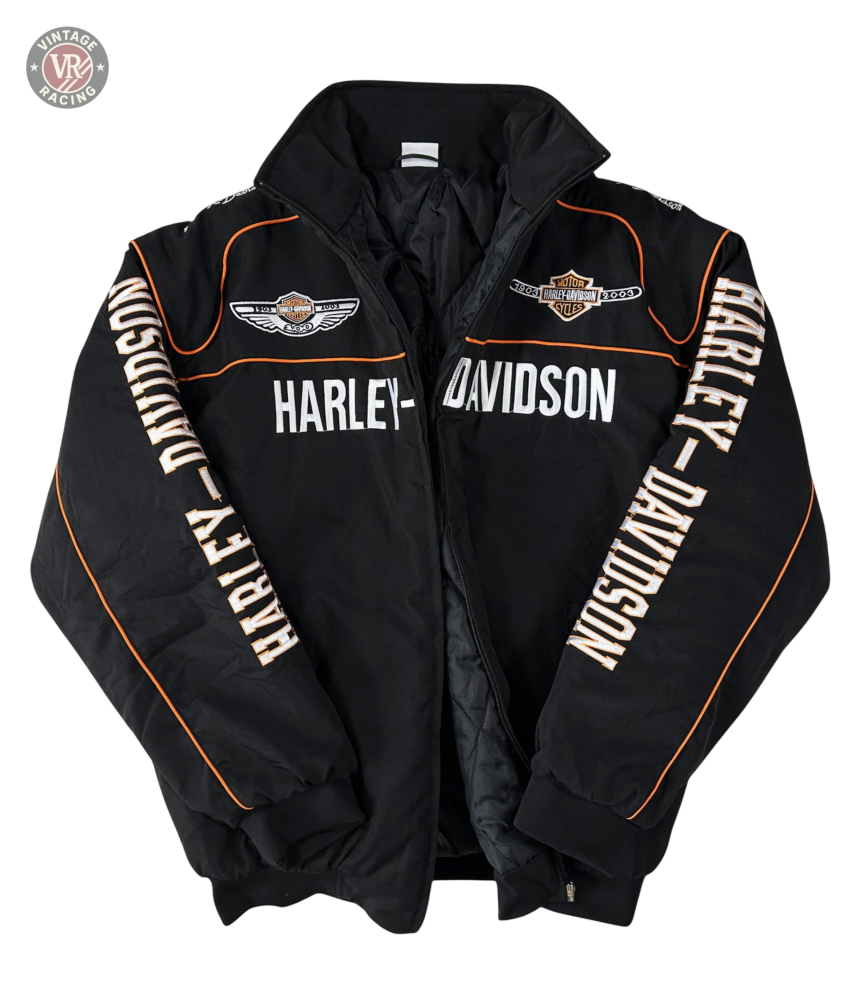 The Vintage Harley Davidson Jacket is black with orange piping, embroidered chest and shoulder logos, and HARLEY-DAVIDSON text on the front and sleeves. The retro motorcycle jacket is displayed flat on a white background.